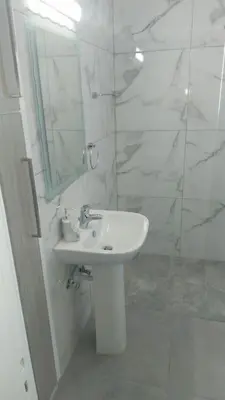 a white bathroom with a sink and a mirror at Tourist Hot Spot Location in Limassol