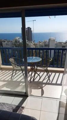 a table and chairs on a balcony with a view of the ocean at Peaceful Beach Location in Limassol
