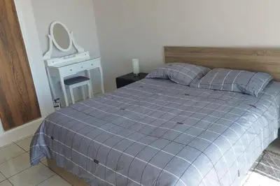 a bedroom with a bed and a desk with a mirror at Peaceful Beach Location in Limassol