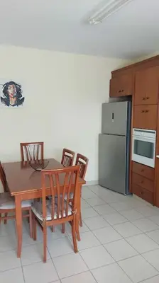 a kitchen with a table and chairs and a refrigerator at Balcony Sea View Whole Apt, Minutes To Beach in Limassol