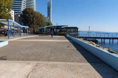 a person walking on a sidewalk next to the water at Balcony Sea View Whole Apt, Minutes To Beach in Limassol