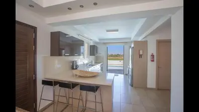 a kitchen with a island with bar stools at Protaras Katerina Villa Kv53 in Paralimni
