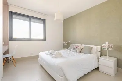 a white bedroom with a large bed and a window at PROTEA RESIDENCE with private terrace in Nicosia