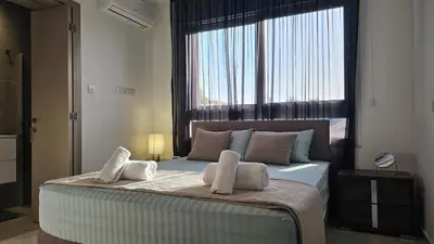 a bedroom with a large bed with a large window at STAY Digital Den Apartment in Larnaka