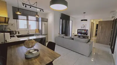 a kitchen and living room with a table and a couch at STAY Digital Den Apartment in Larnaka