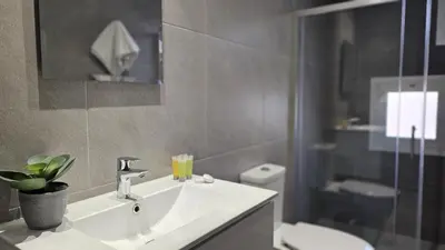 a bathroom with a sink and a toilet and a mirror at STAY Digital Den Apartment in Larnaka