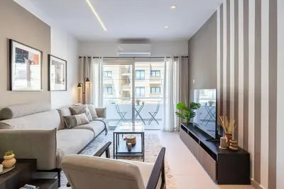 a living room with a couch and a tv at Hazel - 2-Bedroom Apartment in Larnaca in Larnaka
