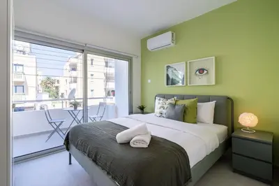 a bedroom with a large bed and a balcony at Hazel - 2-Bedroom Apartment in Larnaca in Larnaka