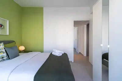 a bedroom with a bed and a green wall at Hazel - 2-Bedroom Apartment in Larnaca in Larnaka