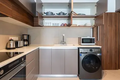 a kitchen with a washing machine and a microwave at Hazel - 2-Bedroom Apartment in Larnaca in Larnaka