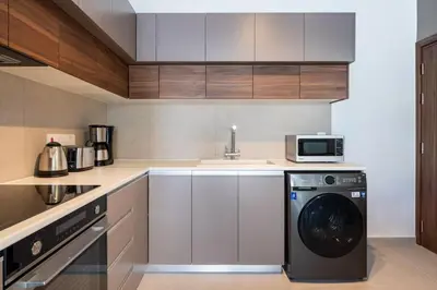 a kitchen with a washing machine and a microwave at Hazel - 2-Bedroom Apartment in Larnaca in Larnaka