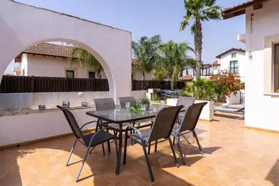 a patio with a table and chairs on a patio at Lumina 2-Bedroom Villa and Pool in Ayia Napa in Ayia Napa