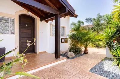 a house with a black door and some plants at Lumina 2-Bedroom Villa and Pool in Ayia Napa in Ayia Napa