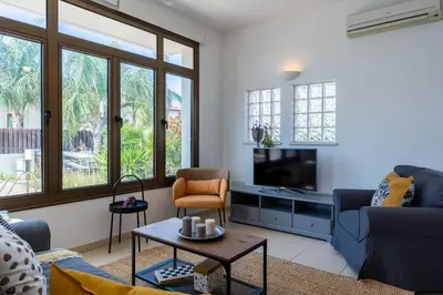 a living room with a couch and a tv at Lumina 2-Bedroom Villa and Pool in Ayia Napa in Ayia Napa