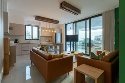 a living room with two couches and a kitchen at Beachcomber 2-Bedroom Apartment in Larnaca in Larnaka