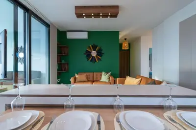 a living room with a couch and a table with wine glasses at Beachcomber 2-Bedroom Apartment in Larnaca in Larnaka