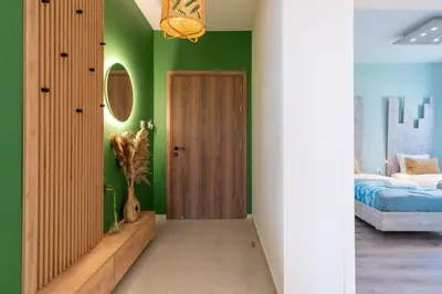 a bedroom with green walls and a bed and a door at Beachcomber 2-Bedroom Apartment in Larnaca in Larnaka