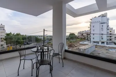 a dining room with a table and chairs and a large window at Beachcomber 2-Bedroom Apartment in Larnaca in Larnaka