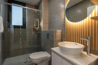 a bathroom with a sink and a toilet and a shower at Beachcomber 2-Bedroom Apartment in Larnaca in Larnaka