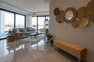 a living room with a couch and mirrors on the wall at Thálassa 2-Bedroom Apartment in Larnaca in Larnaka
