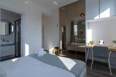 a bedroom with a large bed and a bathroom at Thálassa 2-Bedroom Apartment in Larnaca in Larnaka