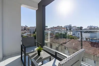 a balcony with two chairs and a view of a city at Stars 1-Bedroom Apartment in Larnaca in Larnaka