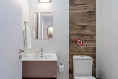 a bathroom with a sink and a toilet and a mirror at Stars 1-Bedroom Apartment in Larnaca in Larnaka