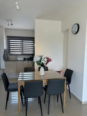 a dining room table with chairs and a vase of flowers at Kyklades Resort Excellence in Paralimni