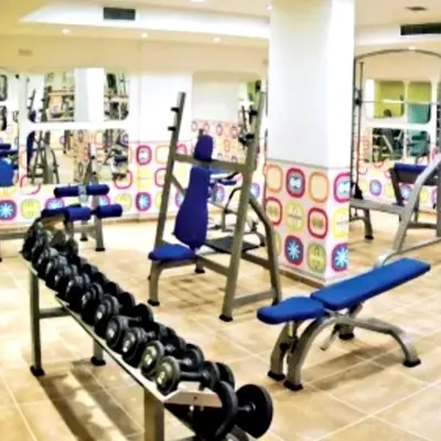 a gym with rows of treadmills and weights at Kyklades Resort Excellence in Paralimni