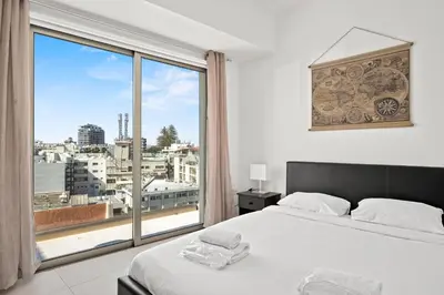 a bedroom with a bed and a large window at Downtown 2 Bedroom Penthouse in Larnaka