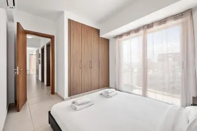 a bedroom with a large bed and a large window at Downtown 2 Bedroom Penthouse in Larnaka