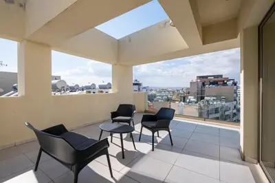 a balcony with chairs and a view of a city at Downtown 2 Bedroom Penthouse in Larnaka