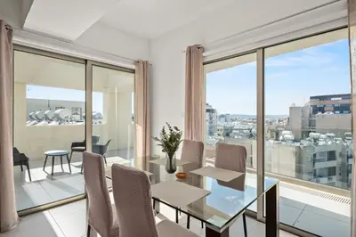a dining room with a glass table and chairs at Downtown 2 Bedroom Penthouse in Larnaka