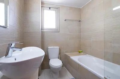 a bathroom with a toilet and a tub and a sink at Downtown 2 Bedroom Penthouse in Larnaka