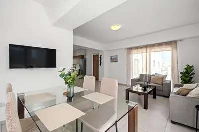a living room with a glass table and a couch at Downtown 2 Bedroom Penthouse in Larnaka