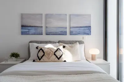 a bedroom with a bed with two paintings on the wall at Moon Light 1-Bedroom Apartment in Larnaca in Larnaka