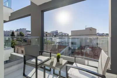 a balcony with a table and chairs and a large window at Moon Light 1-Bedroom Apartment in Larnaca in Larnaka