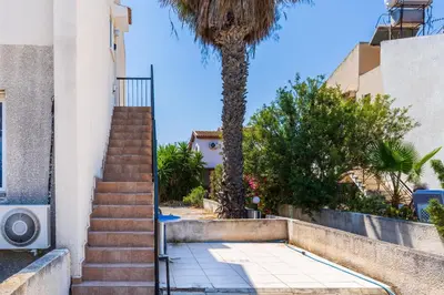 a stairway leading up to a building with a palm tree at Lazuli Stylish 1-BR Apt W Pool & Balcony in Larnaca in Voroklini