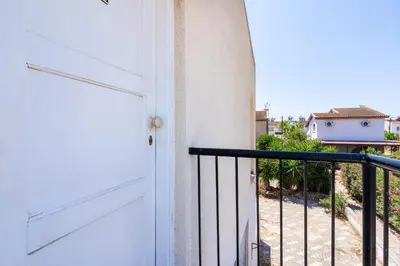 a door to a balcony with a view of a house at Lazuli Stylish 1-BR Apt W Pool & Balcony in Larnaca in Voroklini