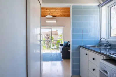 a kitchen with a sink and a door to a patio at Lazuli Stylish 1-BR Apt W Pool & Balcony in Larnaca in Voroklini