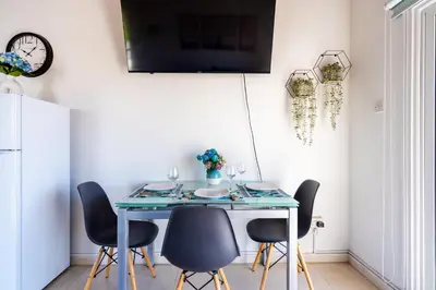 a dining room with a blue table and chairs at Lazuli Stylish 1-BR Apt W Pool & Balcony in Larnaca in Voroklini