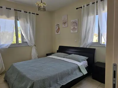 a bedroom with a bed and two windows at The Brilliant Villa in Protaras