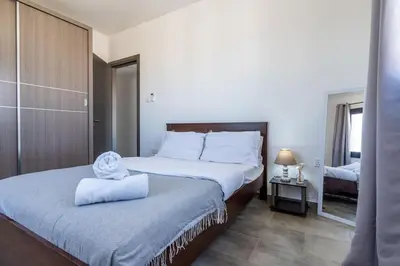 a bedroom with a bed with a towel on it at Maryam's 2-BR Apt Facing Larnaca Harbor With Pool in Larnaka