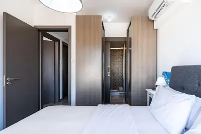 a bedroom with a white bed and a bathroom at Maryam's 2-BR Apt Facing Larnaca Harbor With Pool in Larnaka