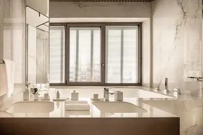 a bathroom with two sinks and a large window at Amathus Residences in Limassol
