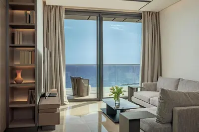 a living room with a couch and a large window at Amathus Residences in Limassol