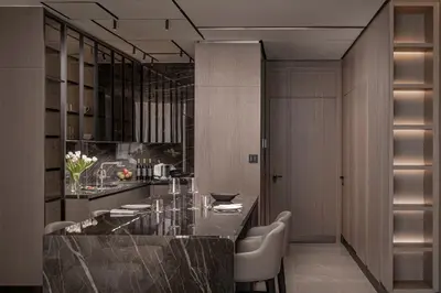 a kitchen with a large black counter with chairs at Amathus Residences in Limassol