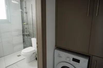 a bathroom with a toilet and a washing machine at Nissi Route 76 in Ayia Napa