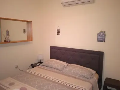 a bedroom with a bed and a mirror at Xylophagou Larnaca Ayia Napa Sunshine Apartments in Xylophaghou