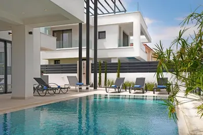 a house with a swimming pool in front of a building at Levanda Platinum - Sunrise Sea View in Protaras